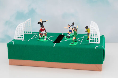 A small soccer field with figurines on it.