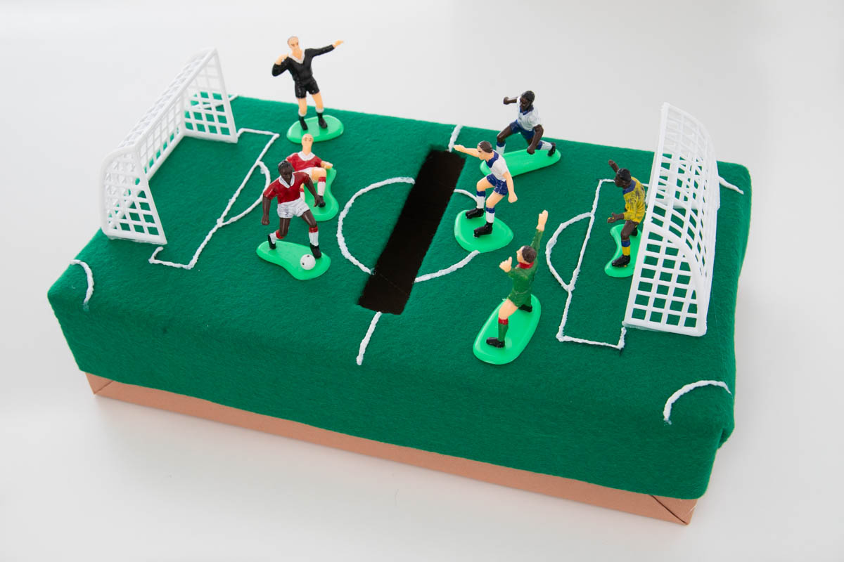 A soccer themed valentine box with figurines on it.