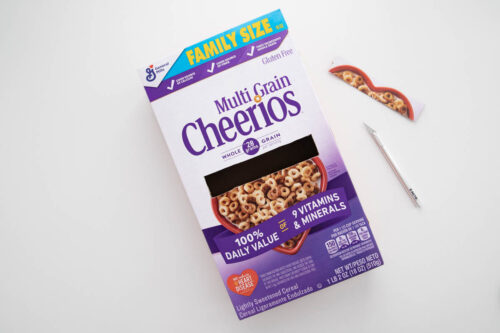 A box of multi grain cheerios next to a craft knife