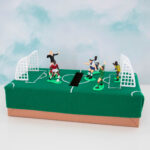 A soccer themed gift box with figurines on top.