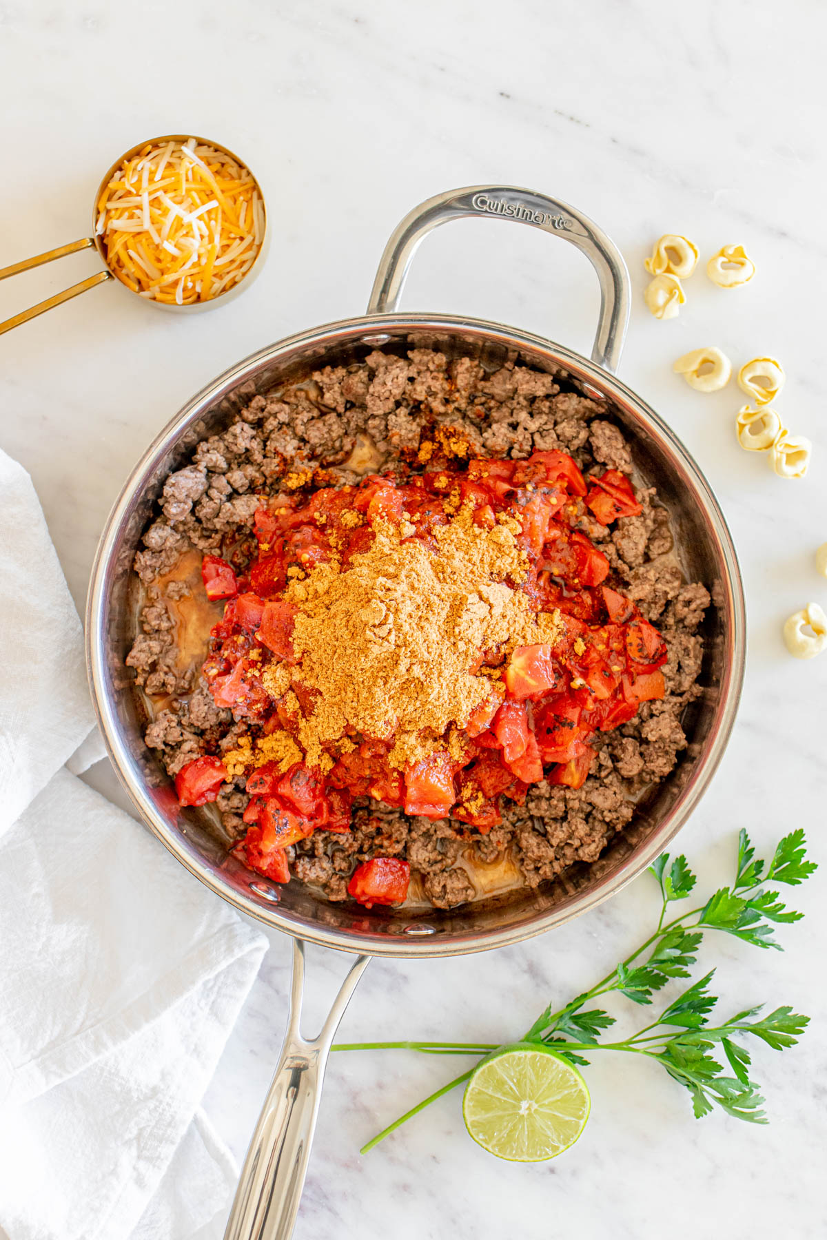 A skillet filled with a ground beef, tomatoes and spices