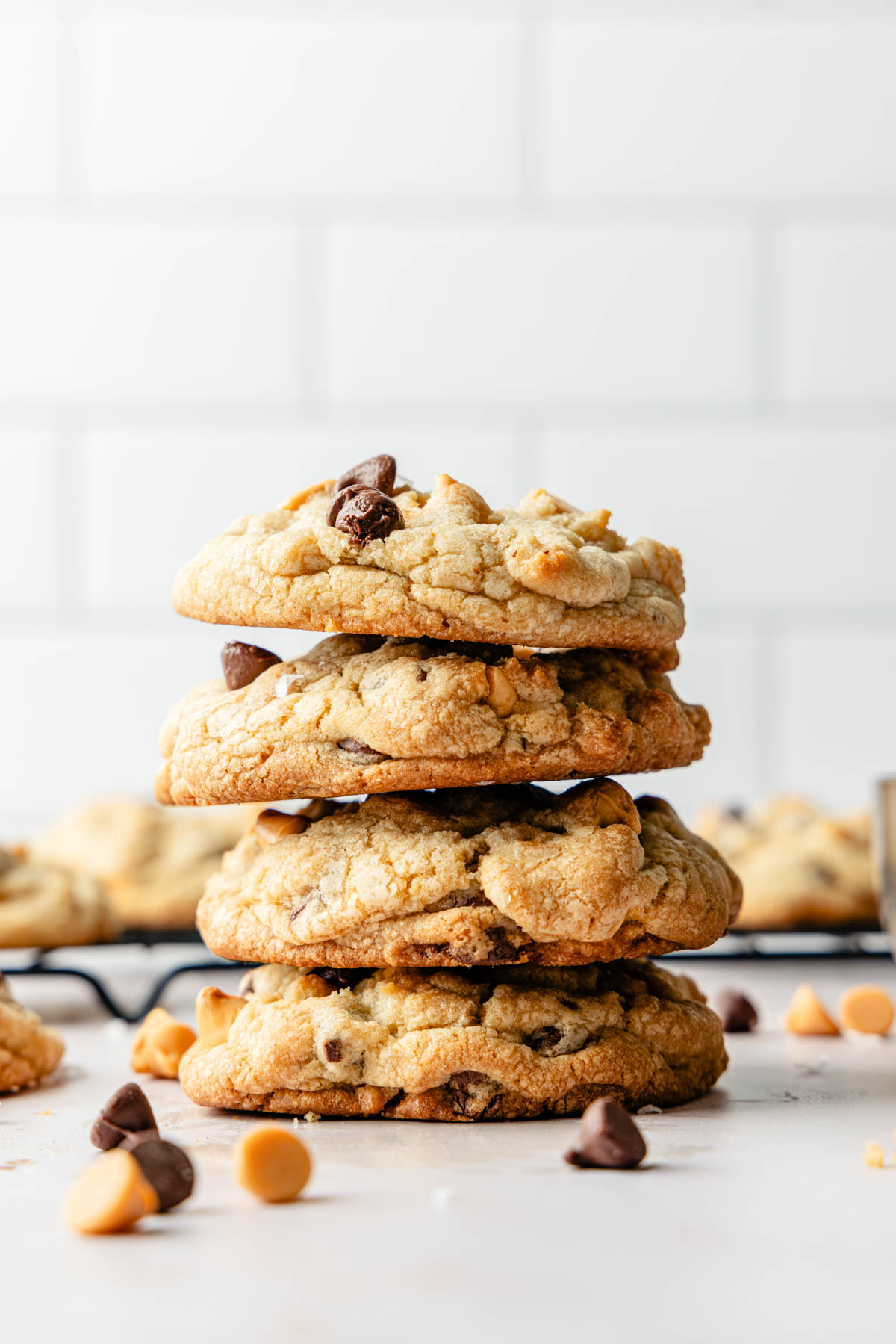 A stack of chocolate chip butterscotch cookies on a cooling rack.