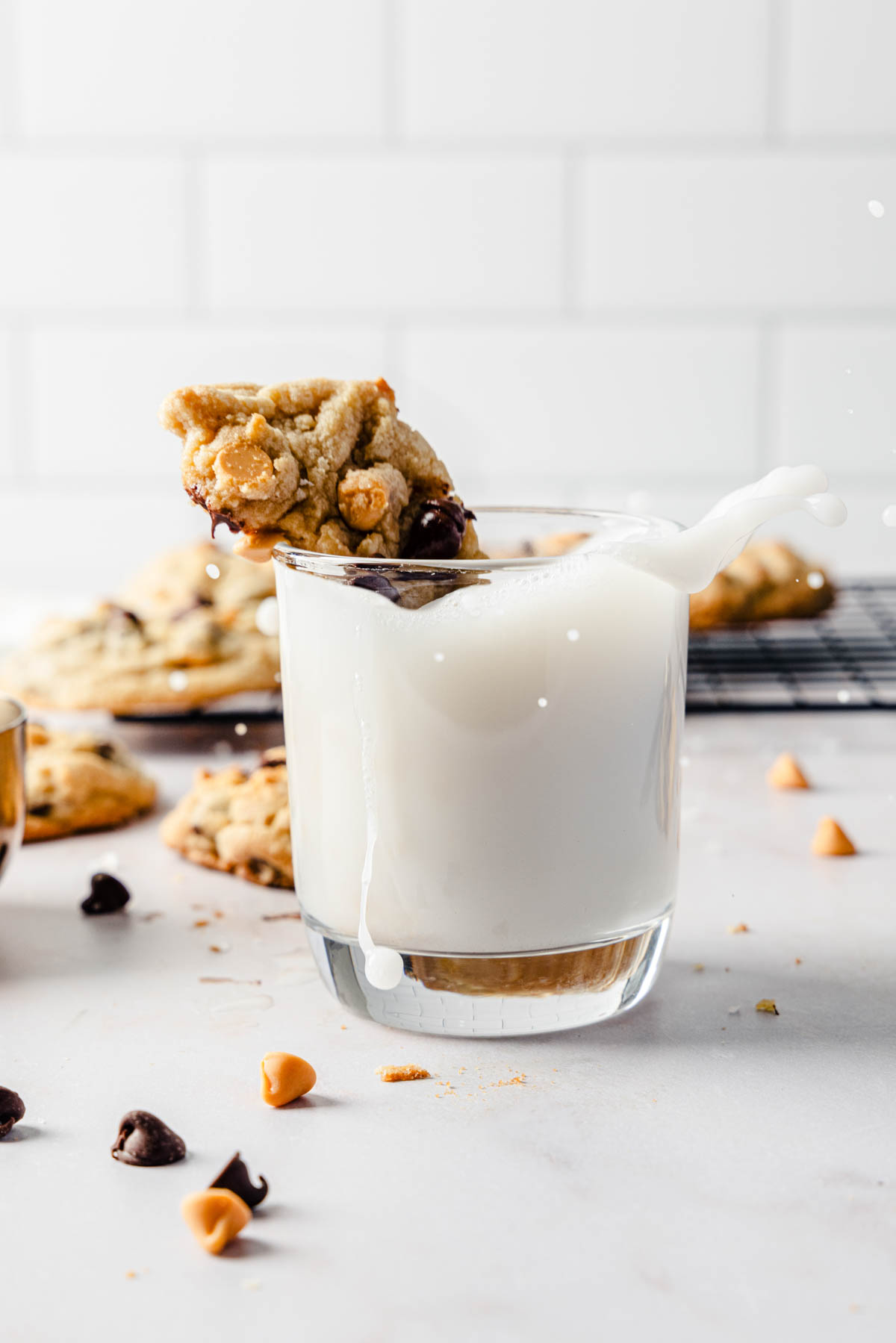A glass of milk with a cookie in it.