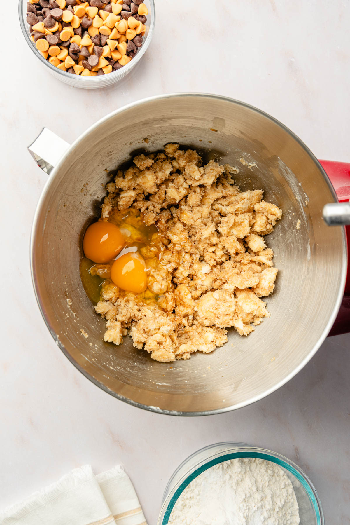 A mixing bowl with ingredients for butterscotch chocolate chip cookies