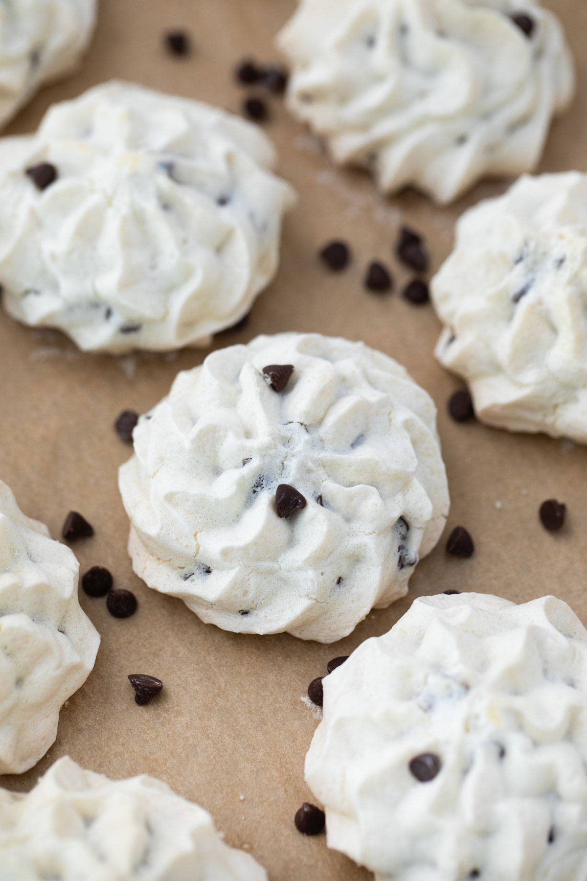 Chocolate chip meringue cookies on a baking sheet.