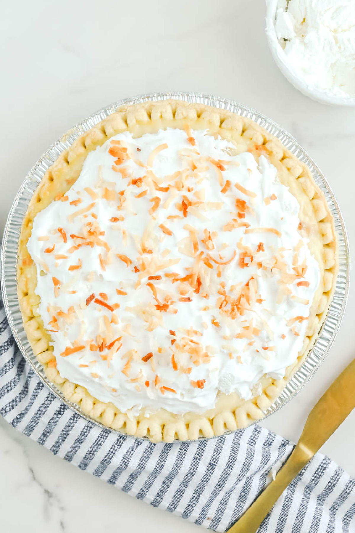 A coconut pie with whipped cream on top.