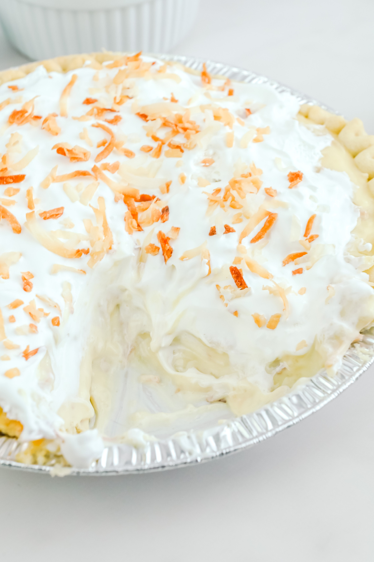 A coconut pie with whipped cream and coconut on top.