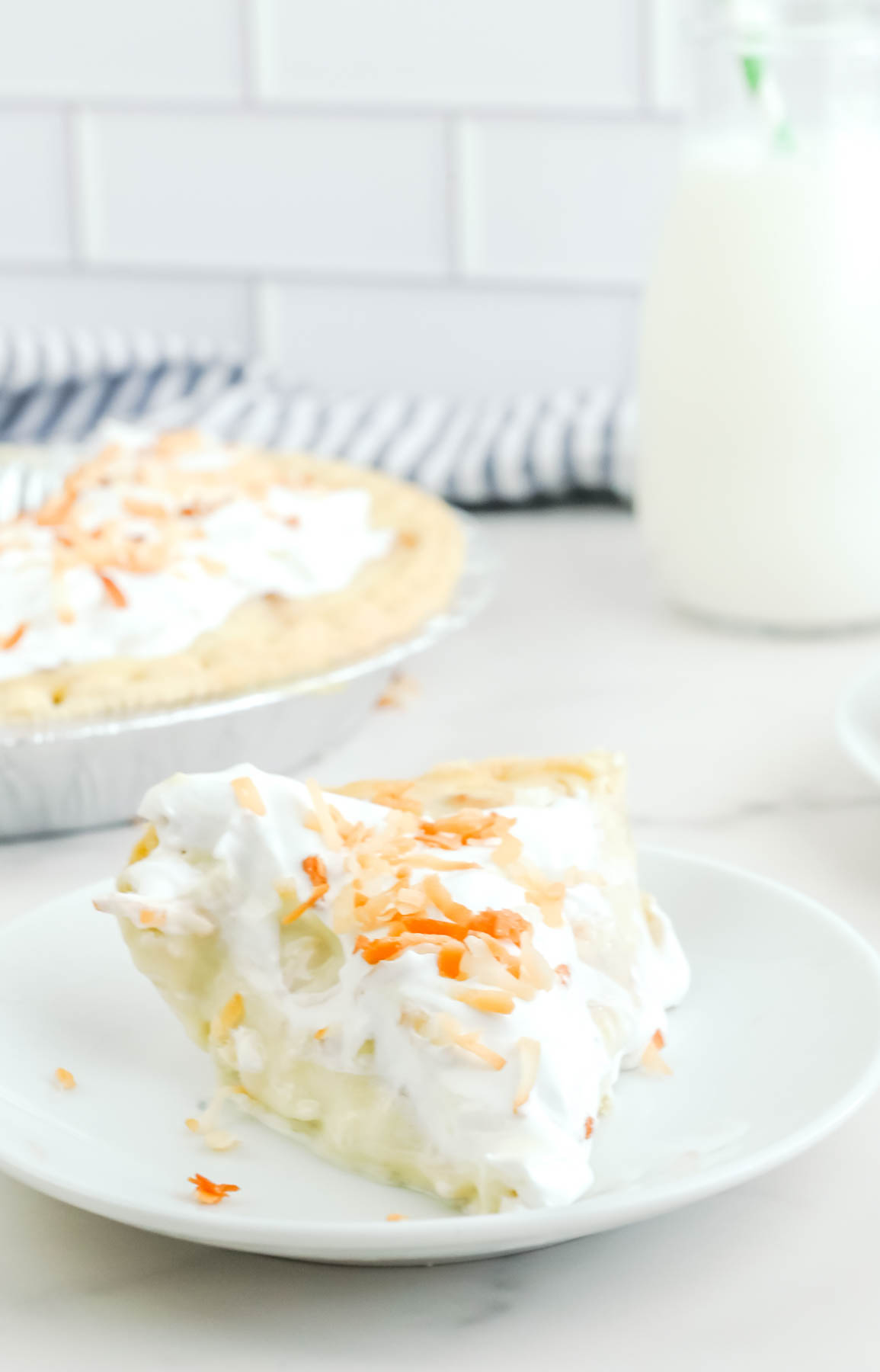A slice of coconut cream pie on a plate.