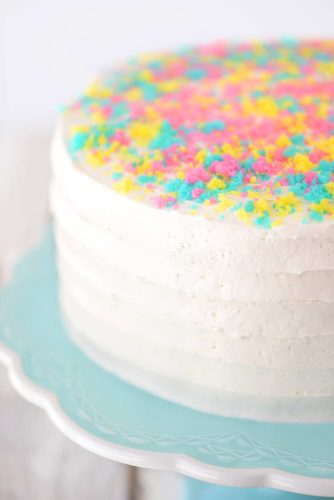 A white cake with colorful sprinkles on top.