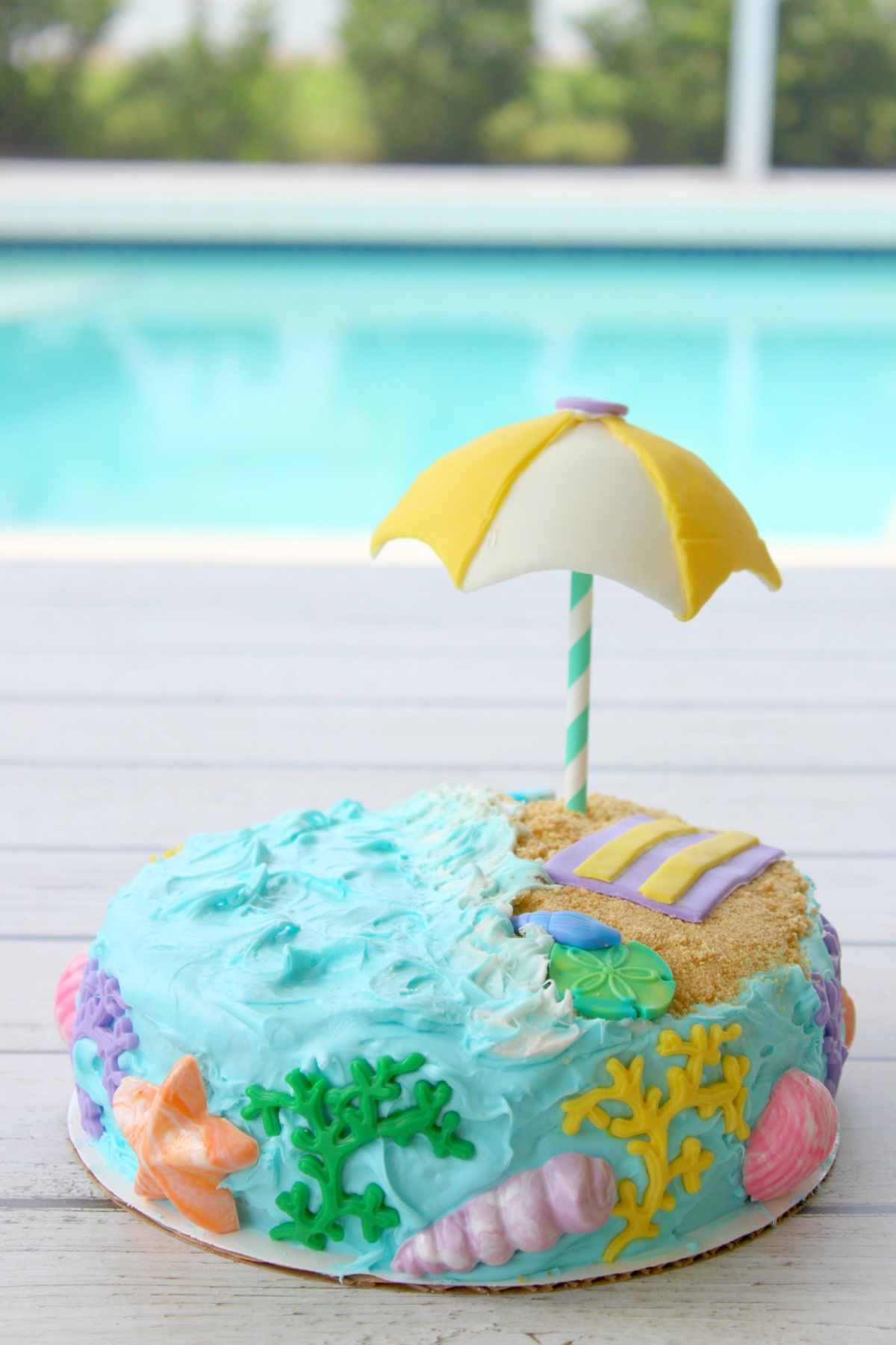 A beach cake adorned with an umbrella, perfect for a summer celebration.