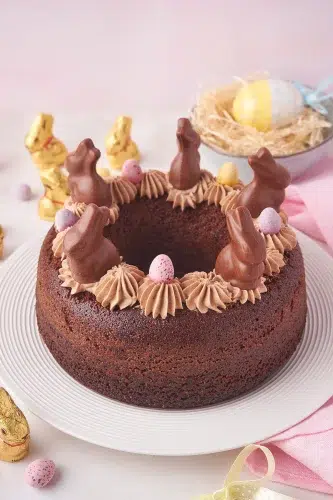 A chocolate cake decorated with easter eggs on a plate.
