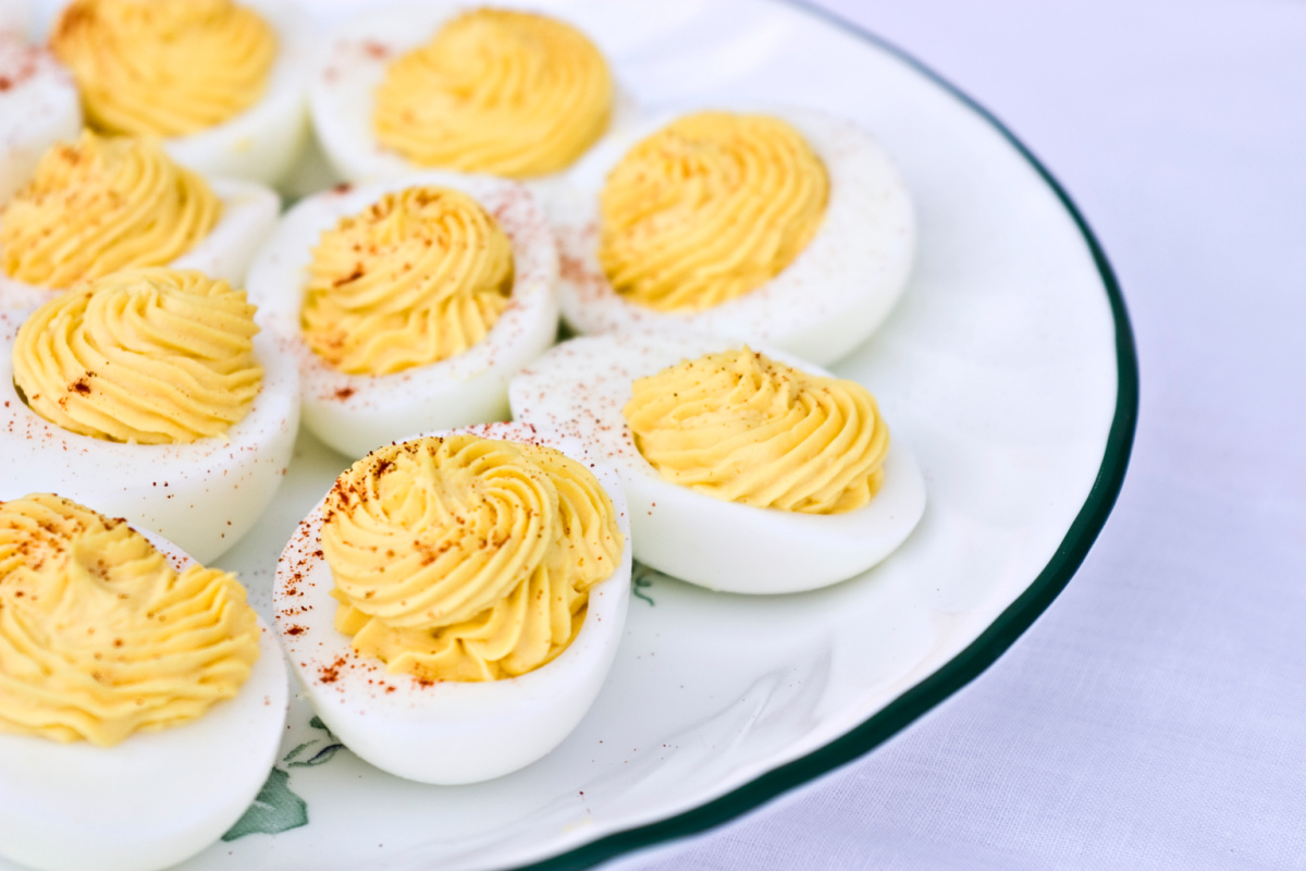 A plate of deviled eggs garnished with paprika.