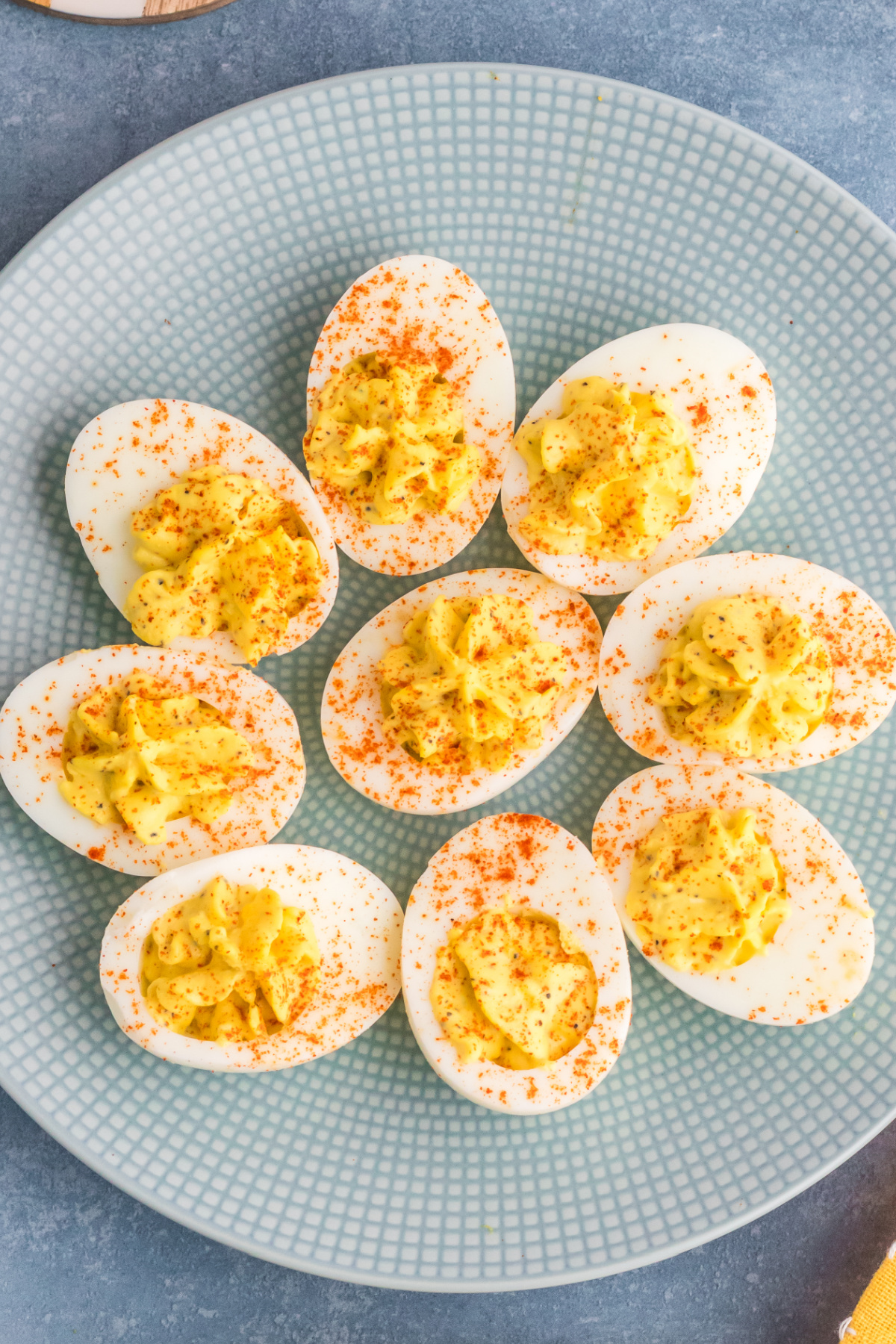A plate of deviled eggs sprinkled with paprika.