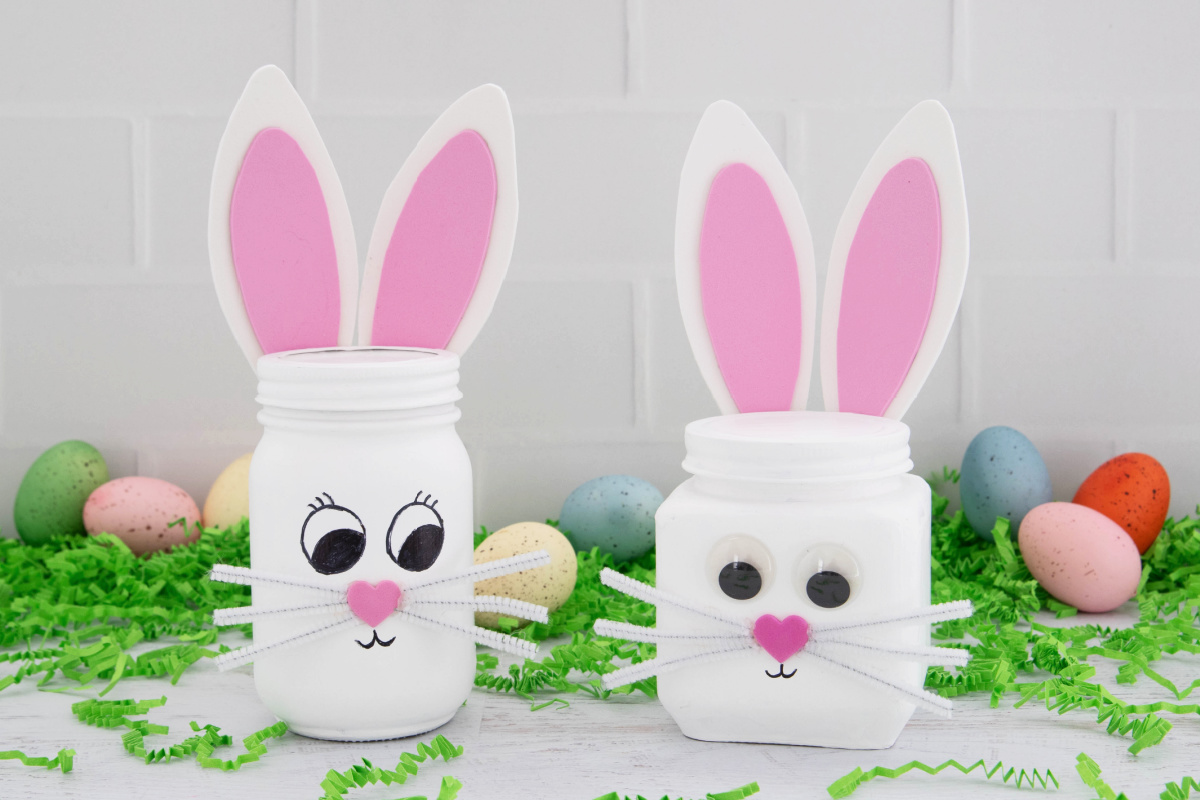 Two decorated jars resembling bunny faces, with easter eggs and green confetti in the background.