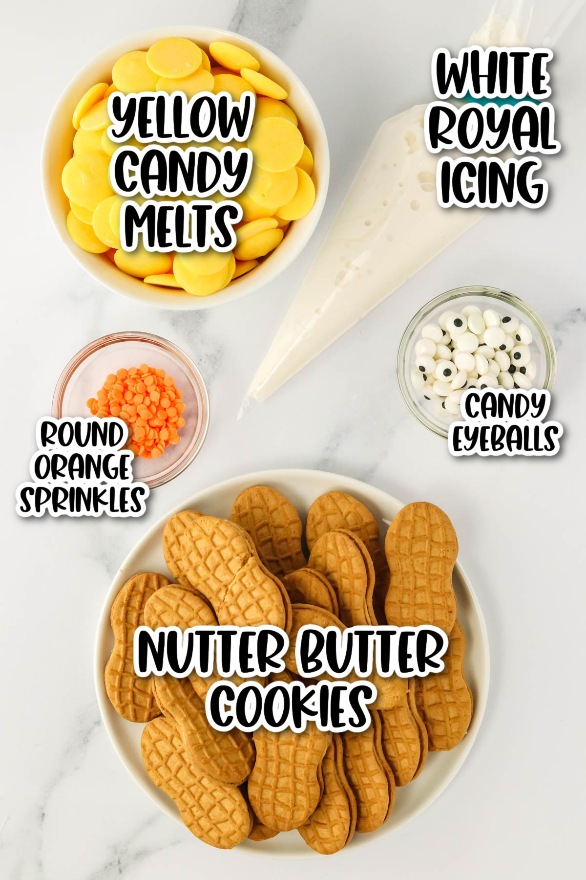 Ingredients for making decorated cookies: yellow candy melts, white royal icing, round orange sprinkles, candy eyeballs, and nutter butter cookies.