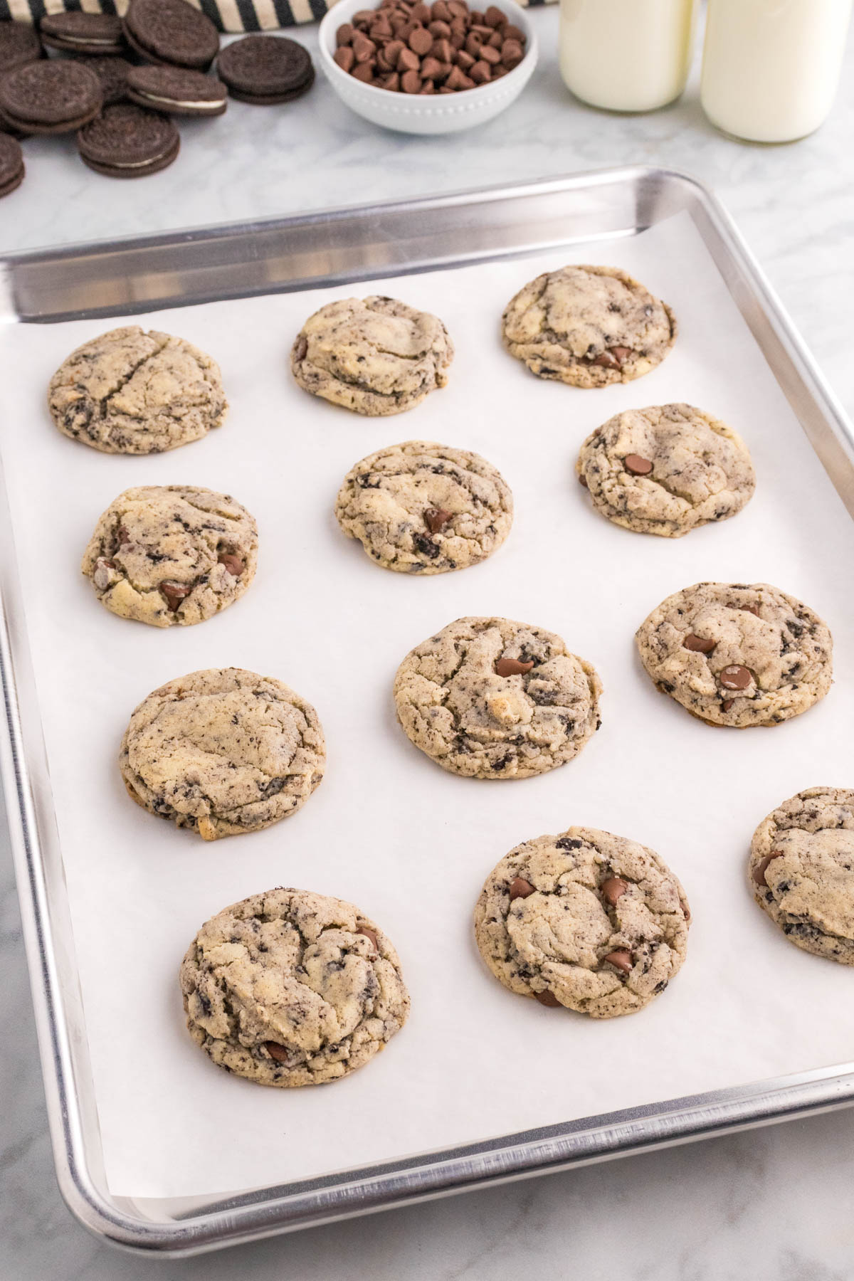 Freshly baked cookies with chocolate chips and chunks on a baking tray.