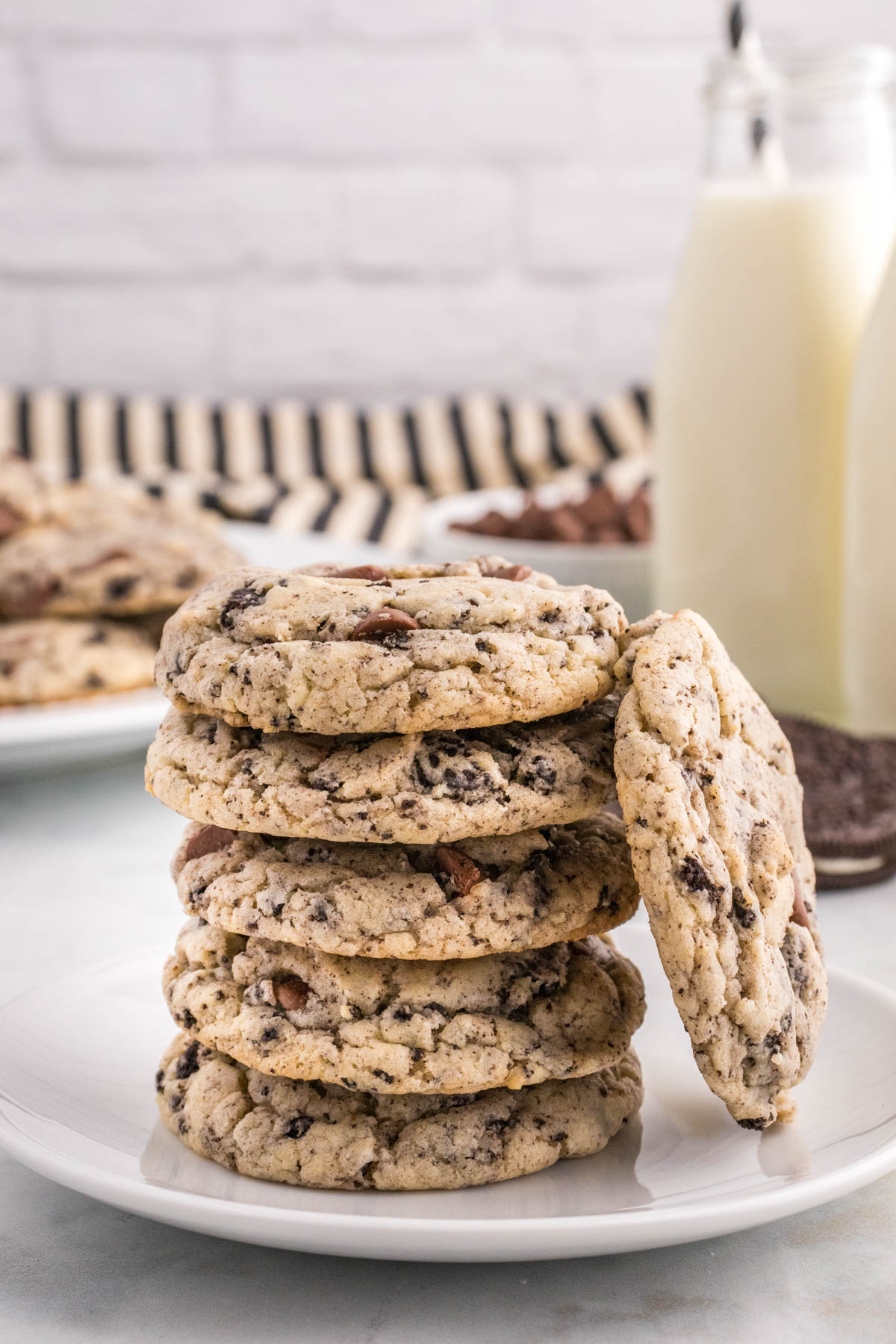 A stack of Oreo Cake Mix cookies on a plate with a glass of milk in the background.