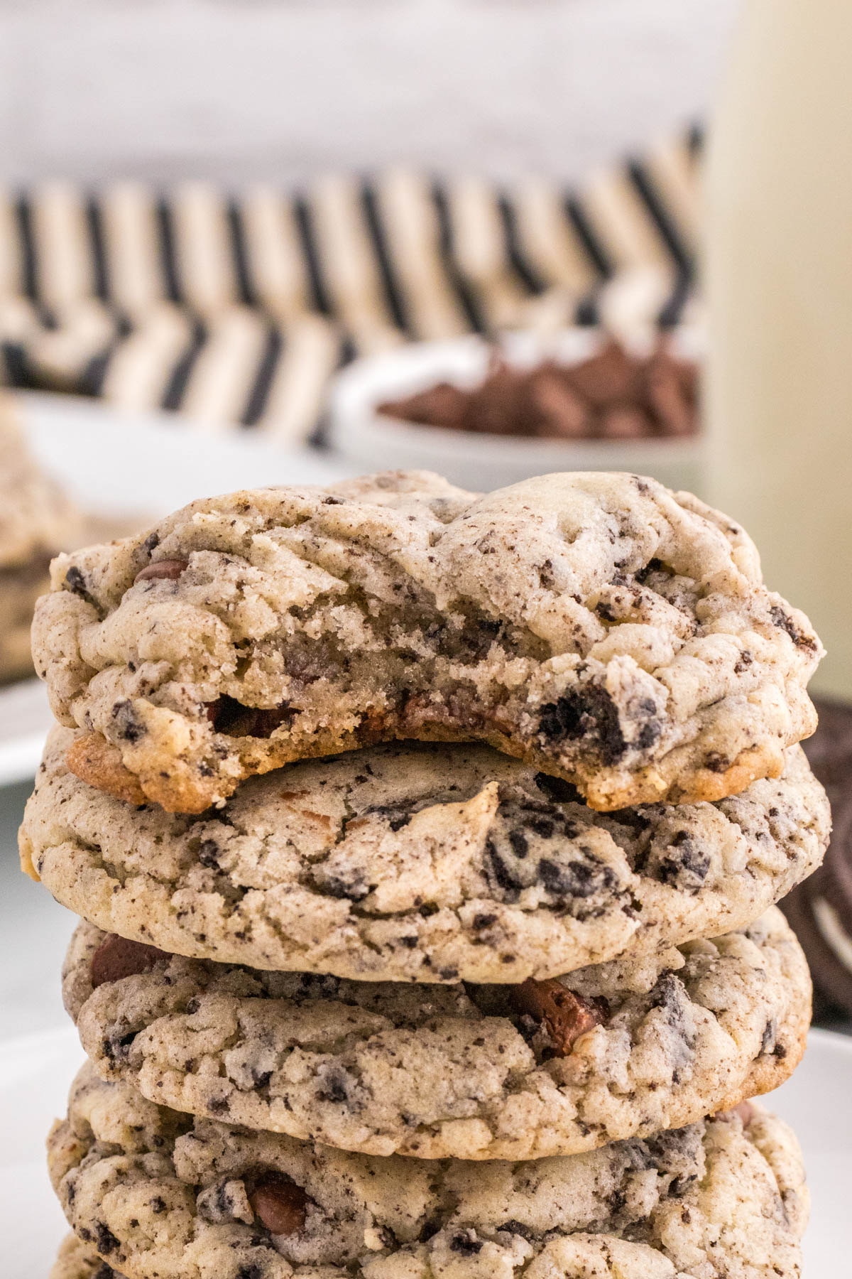 A stack of Oreo chocolate chip cookies on a plate with a blurred background.