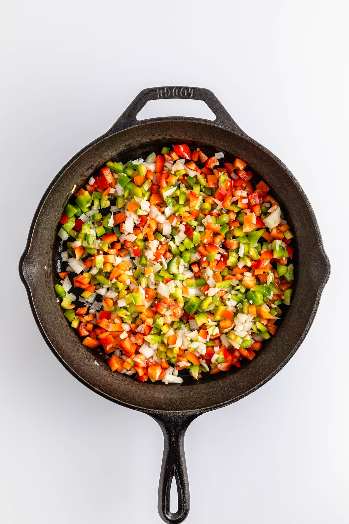 Diced vegetables in a cast iron skillet.