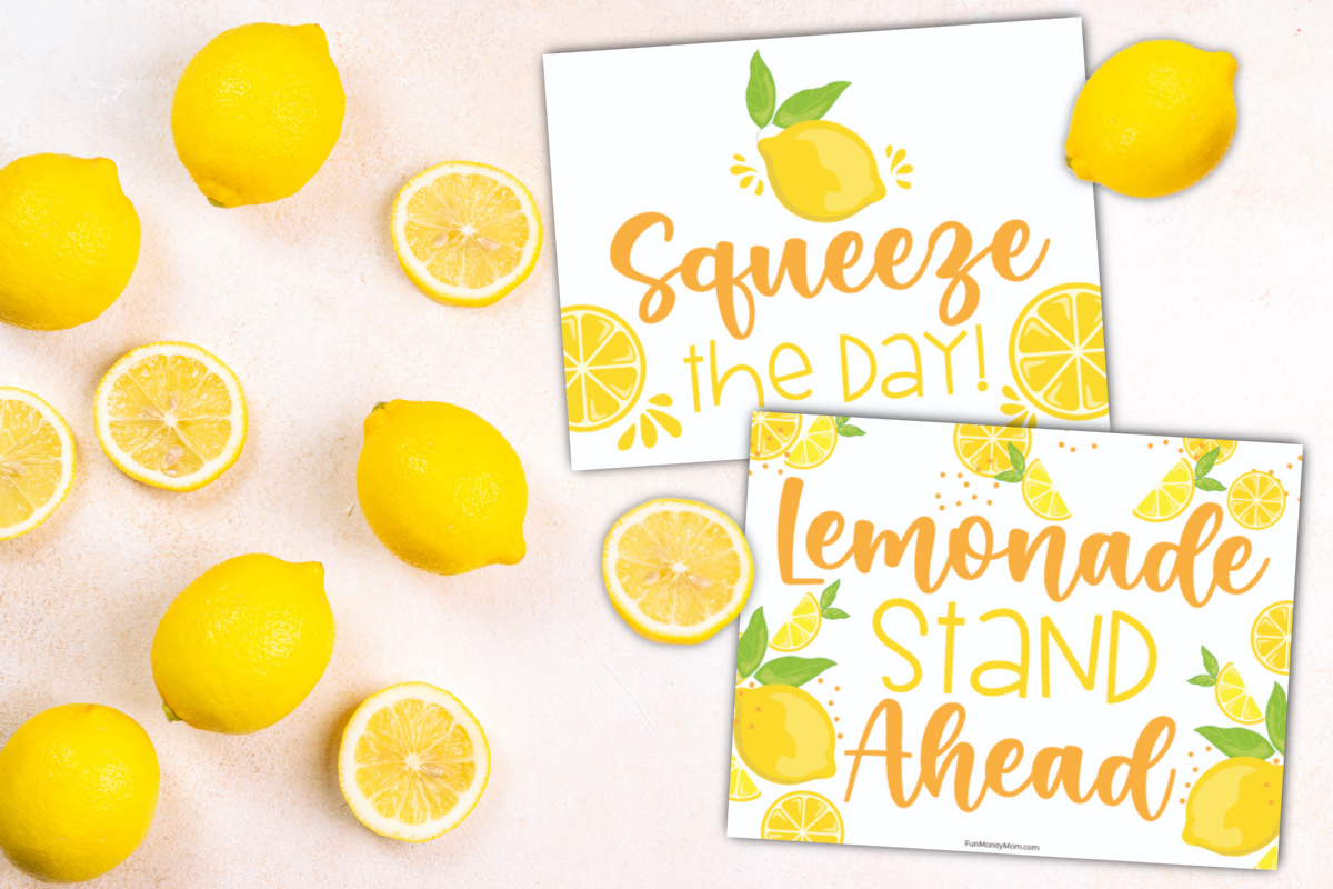 A display of fresh lemons scattered around lemonade stand signs