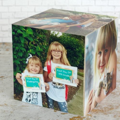 A cube-shaped photo collage featuring various images of two young girls in different settings, including a school-themed picture, perfect for Mother's Day crafts.