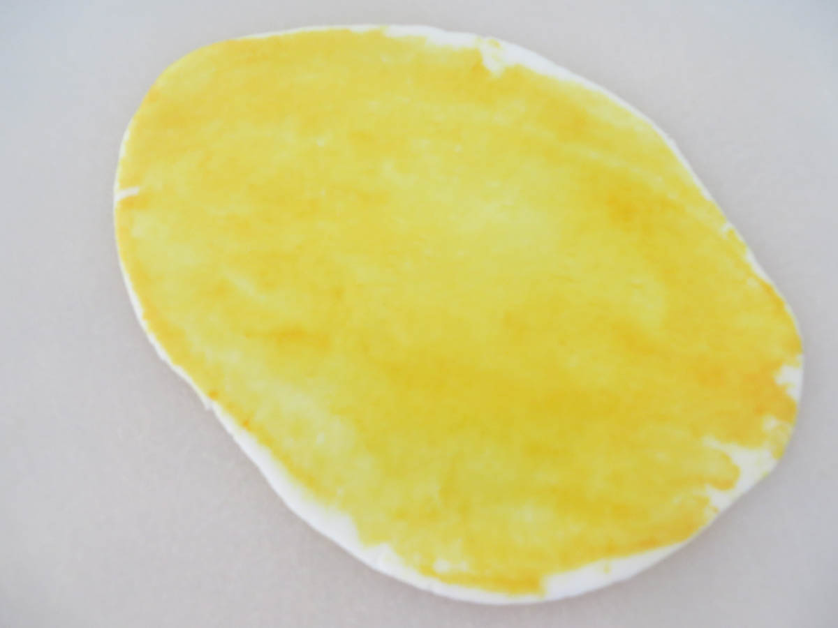 A close-up image of a fried egg with a white edge and a bright yellow yolk, pictured against a light background.
