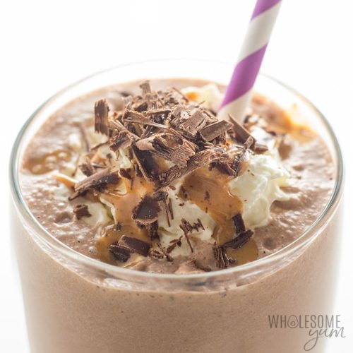 Chocolate smoothie topped with whipped cream and chocolate shavings, served with a striped straw.