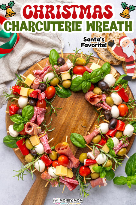 A charcuterie platter arranged in the shape of a Christmas wreath, with meats, cheeses, olives, tomatoes, and herbs on a wooden board.