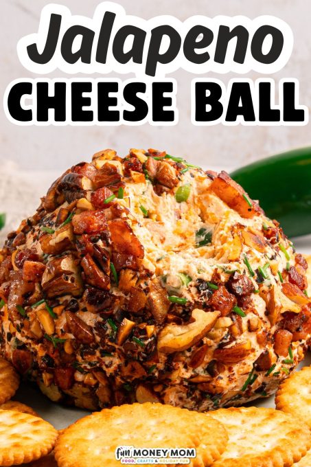 A jalapeno cheese ball coated with chopped nuts and herbs, served on a plate with round crackers.