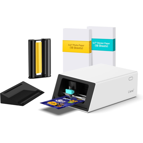 A compact photo printer with a printed photo, two packs of 4x6" paper, a black plastic holder, and a yellow printing cartridge displayed beside it.