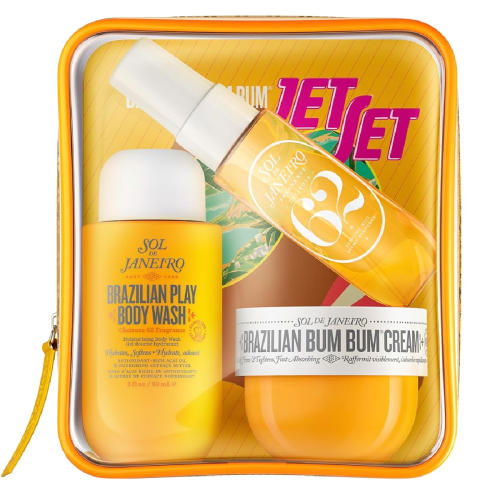 A clear zippered pouch containing Sol de Janeiro Brazilian Play Body Wash, Brazilian Bum Bum Cream, and Cheirosa 62 Body Fragrance Mist, with a yellow and pink Jet Set booklet.