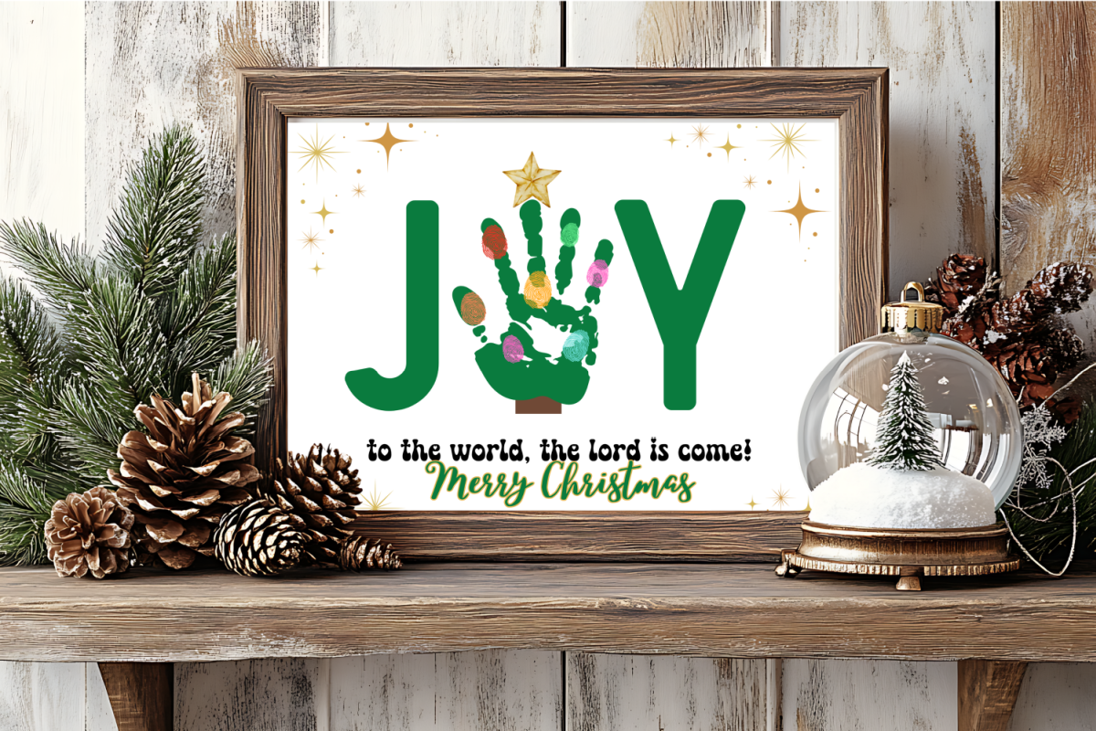 Framed Christmas sign reads "JOY to the world, the Lord is come! Merry Christmas" with a handprint forming the "O," surrounded by pine branches and a snow globe.