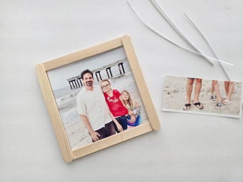 A framed photo of three people standing on a beach with a pier in the background, next to another photo showing only legs and feet in sandals and sneakers on sand.