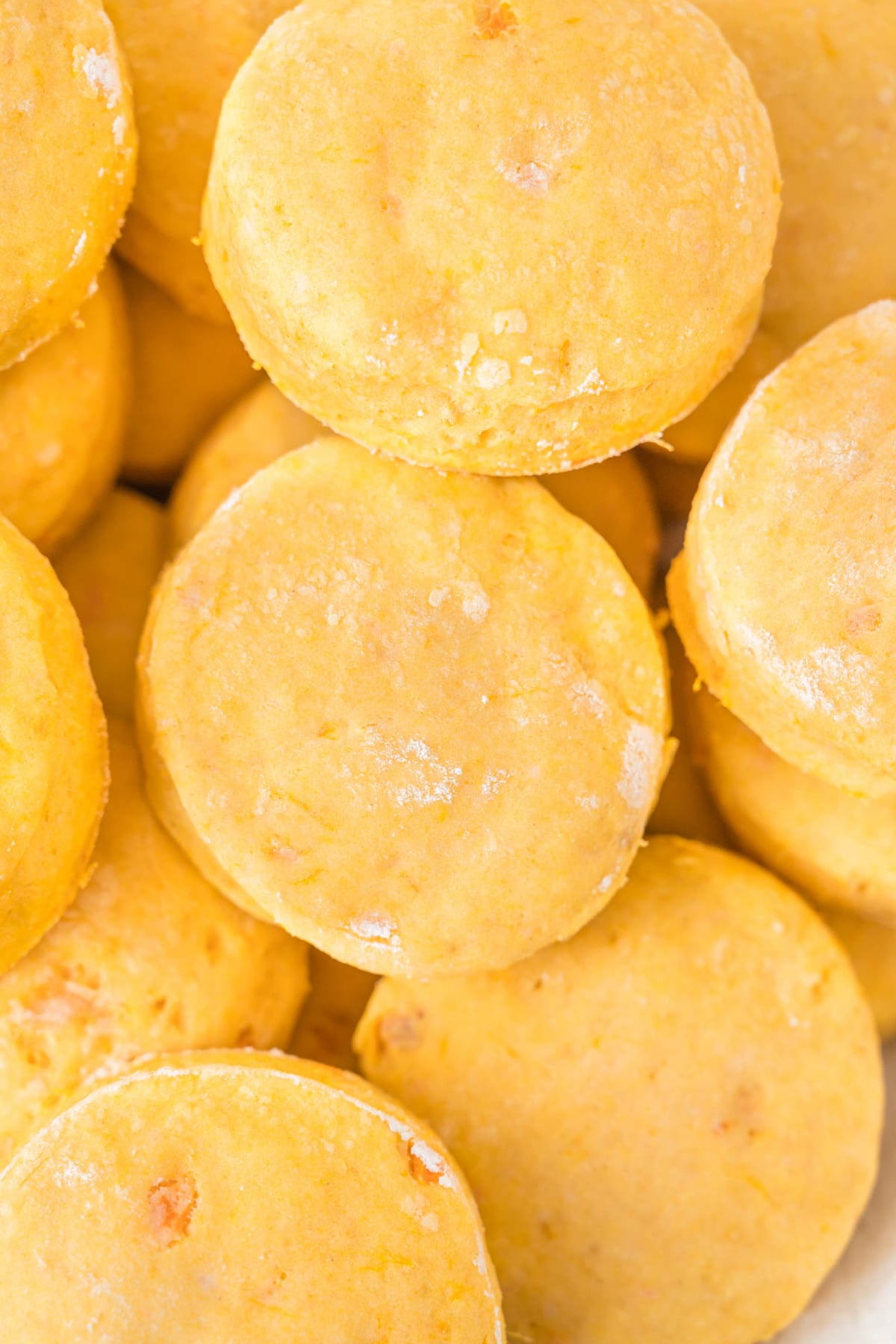 A pile of golden-yellow round biscuits.
